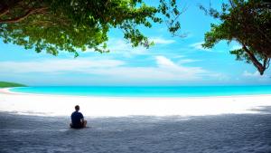 A white beach with one man on it