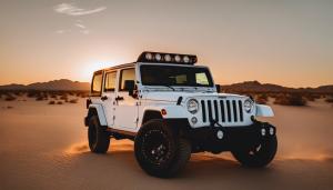 A Jeep Wranger 4 door, white in color in the desert at sunset