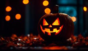 A jack o lantern at Halloween with glowing red eyes, with monster around it