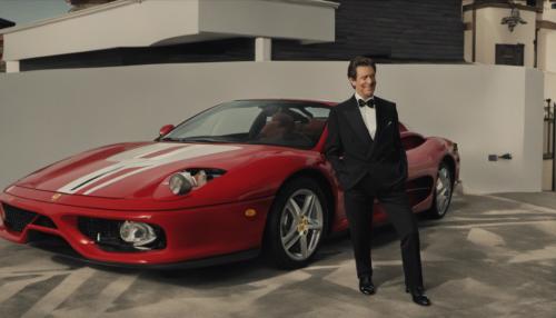 Ted standing on a ferrari in a tuxedo